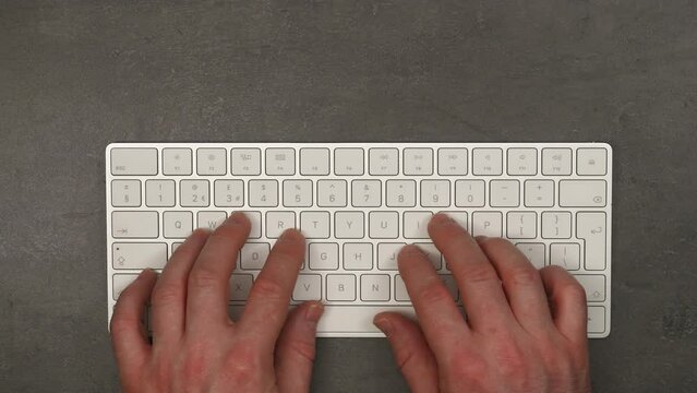 Man typing very fast on a wireless keyboard. Busy day, coder, office work, typing concept. Top view, 4K stop motion animation.