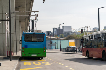Electric bus at a stop is charged by pantograph. Clean mobility.