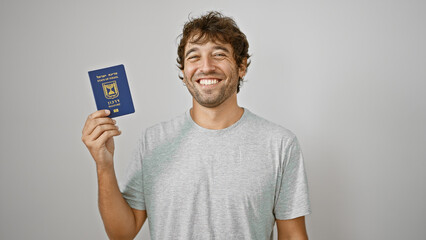 Bearded, blonde, young man standing confident, flashing a joyous smile as he holds his israeli passport aloft, against a white isolated background. adult, casual, happy patriot ready for travel.