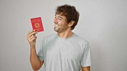 Young man smiling holding passport of italy over isolated white background