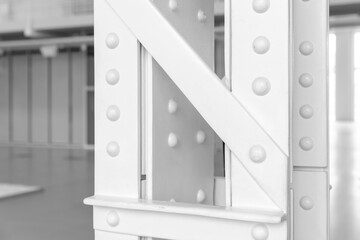 Vintage industrial architecture details, close-up photo of a white steel truss pillar