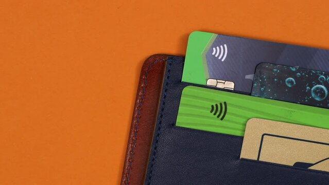 Closeup on leather wallet with debit cards and euro banknotes moving out. Consumer, buying, payment, cash concept. Top view, 4K Stop motion animation. 