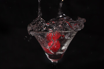 グラスの中のスプラッシュとサクランボ