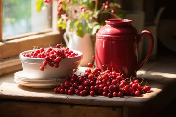 Fotobehang A serene still life of vibrant red currants in a white bowl, with a red jug beside, illuminated by warm sunlight on a wooden surface, evoking a cozy, rustic ambiance. © cvetikmart