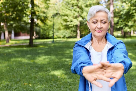 Beautiful Gray Haired Elderly Woman Glue Jacket Posing Outdoors With Closed Eyes Stretching Hands Doing Warm Up Exercise Before Cardio Workout Copyspace Your Advertising Information