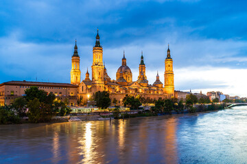 Evening landscape of the Cathedral Basilica of Our Lady of the Pillar on the banks of river Ebro in Zaragoza, Aragon, Spain - 745411729