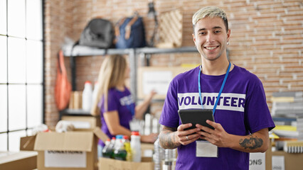 Man and woman volunteers using touchpad working at charity center