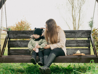 mother and child have a snack on a bench