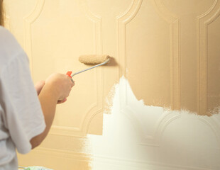 girl paints wallpaper with a roller close-up. repair