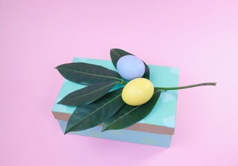 Easter eggs and green leaves on a gift box 