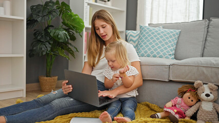 At home, a relaxed caucasian mother and daughter sitting together, engrossed in a movie on the...