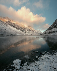 Mountain lake and a snow bank in winter. Loch Achtriochtan. Scottish Highlands