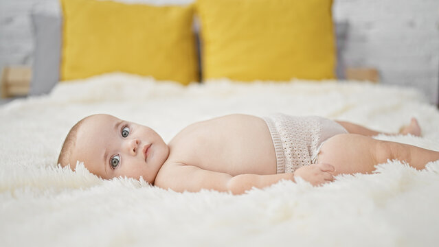 Adorable baby lying in comfort on the bed of a cozy bedroom inside a cute little apartment, embodying the pure lifestyle of a relaxed newborn awakening