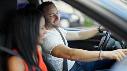 Beautiful couple sitting on car turning on radio at street