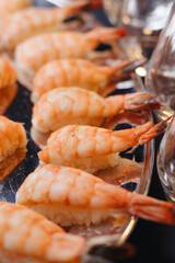 Beautifully decorated catering banquet table with different food snacks and appetizers with sandwich, caviar, fresh fruits on corporate christmas birthday party event or wedding celebration.