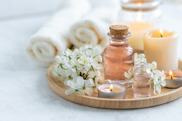 Obraz na płótnie Canvas Concept of pure natural organic ingredients, flowers, herbal extracts in cosmetic beauty products. Perfumery, home fragrance with the scent of blooming spring flowers. Candles, bamboo tray