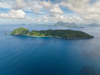 Inambuyod Island surrounded by blue sea. Blue sky and clouds. El Nido, Philippines.
