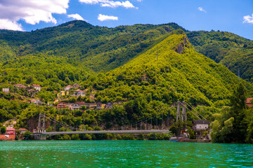 Fototapeta na wymiar Suspension Bridge Over Lake Jablanica Against Verdant Hills, Bosnia and Herzegovina