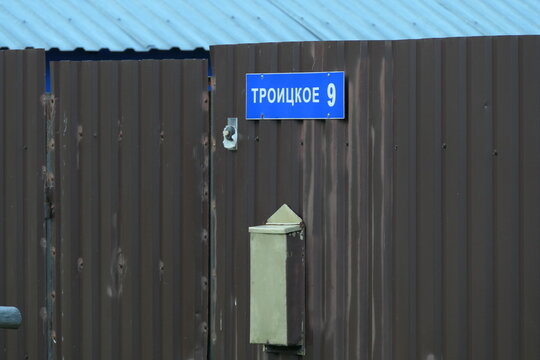 Russian sign on village fence with postbox