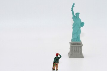 miniature figurine of an hiker looking at the liberty statue in New York city