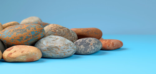 A collection of earth-toned pebbles on a blue backdrop.