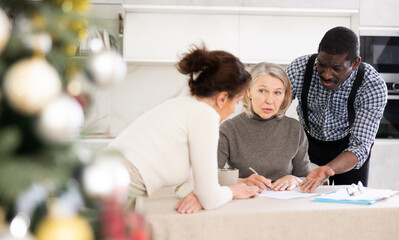 Obraz premium Elderly woman relatives tell her who to include in her will during Christmas celebrations