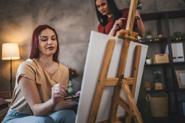 two young women paint at home mentor artist help to create art