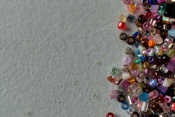 overhead view and macro closeup of multicolored glass beads on a white surface