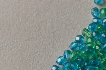 faceted glass beads in blue and green tones on a white surface