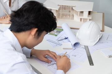 Professional engineer measures house model while skilled interior designer taking a note. Work together, collaboration, cooperative. Creative design and team working concept. Top view. Immaculate.