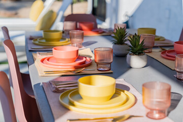 Set dining table outdoors with colorful place settings