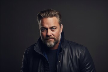 Portrait of a serious mature man in a black leather jacket.