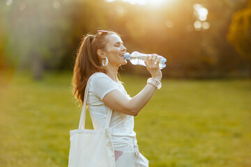 relaxed trendy 40 years old woman in white shirt with tote bag