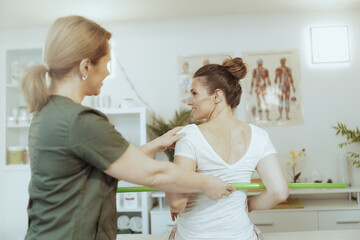 female therapist in massage cabinet conducting examination