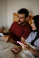 Woman and man reading pregnancy test instructions side by side