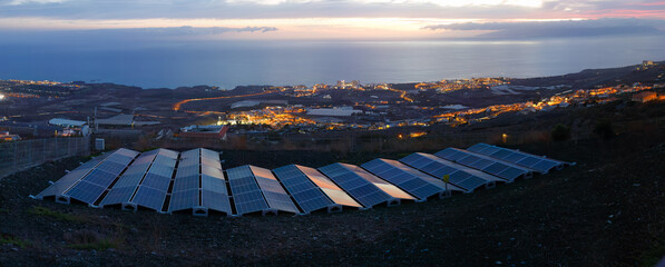 Ground-Level Solar Panels with Coastal City Backdrop