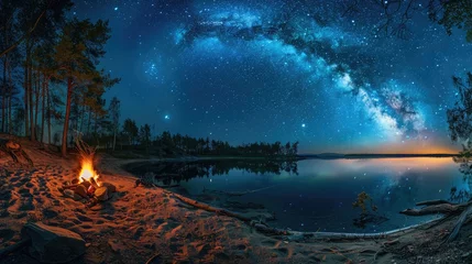 Gordijnen Night camping on shore. campfire under evening sky full of stars and Milky way on blue water and forest background. Outdoor lifestyle concept © buraratn