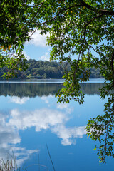 Obraz premium Embark on a tranquil journey to Lake Barrine in the Atherton Tablelands, Queensland, Australia, where serene waters mirror lush rainforest surroundings, inviting serenity and exploration.