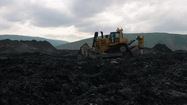 Heavy excavation equipment Driving around the industrial quarry. Heavy excavation equipment digging the ground looking for valuable materials. Heavy excavation equipment collects muddy rocks.