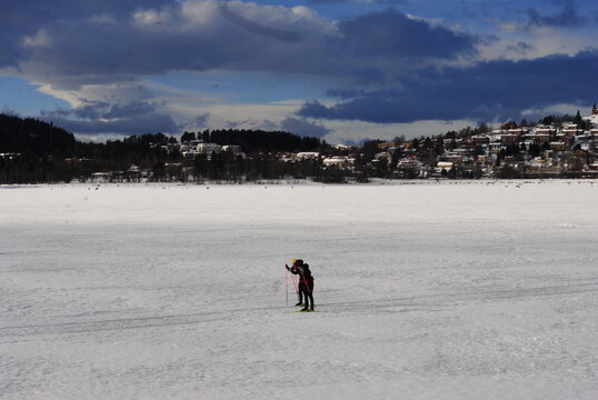 Östersund, Sweden 2024.02.25 
   Park and lake in winter in the city. Winter park in Östersund. People sunbathe, barbecue, ski, and skate.

