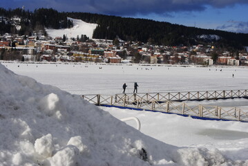 Östersund, Sweden 2024.02.25 
   Park and lake in winter in the city. Winter park in Östersund. People sunbathe, barbecue, ski, and skate.

