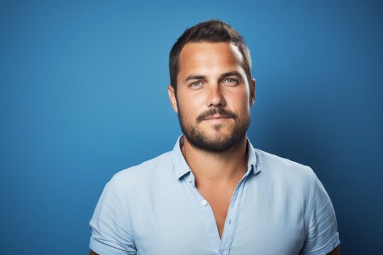 Portrait of a handsome young man with beard on blue background.