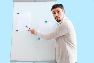 Male tutor giving online lesson near flipboard at home