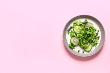 Bowl of tasty vegetable salad on pink background