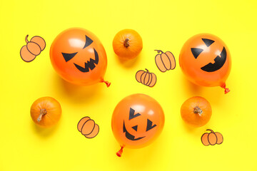 Funny Halloween orange balloons and paper pumpkins on yellow background
