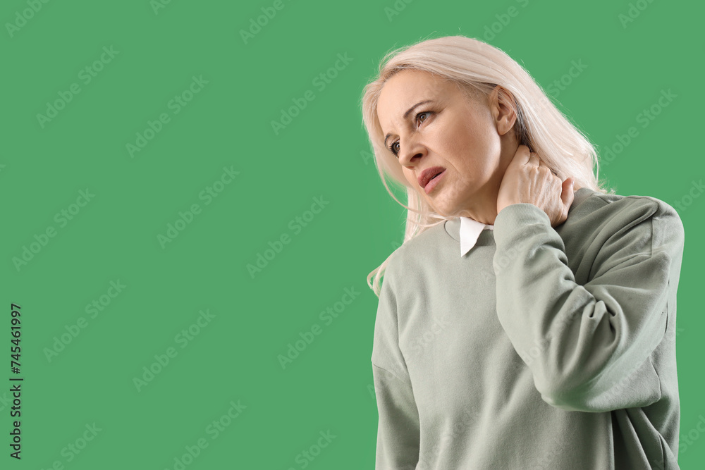 Sticker Mature woman suffering from neck pain on green background