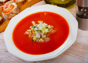 Traditional Spanish refreshing pureed soup Gazpacho from tomatoes served with chopped vegetables..