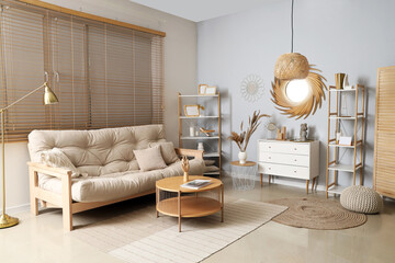 Interior of stylish living room with golden mirror, commode and sofa