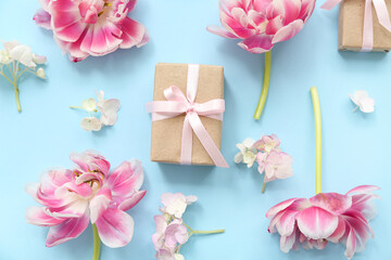 Composition with gift box and beautiful flowers on cyan background