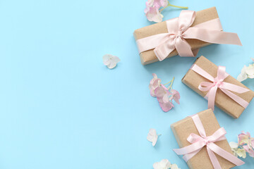 Composition with cute gift boxes and flowers on cyan background